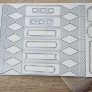 Cracker & Treat Box Dies laid out on magnetic sheet showing cracker box die, labels, tags, hearts, and stars.