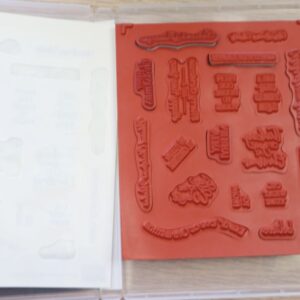 Open Itty Bitty Christmas stamp case showing the red rubber cling stamps inside.