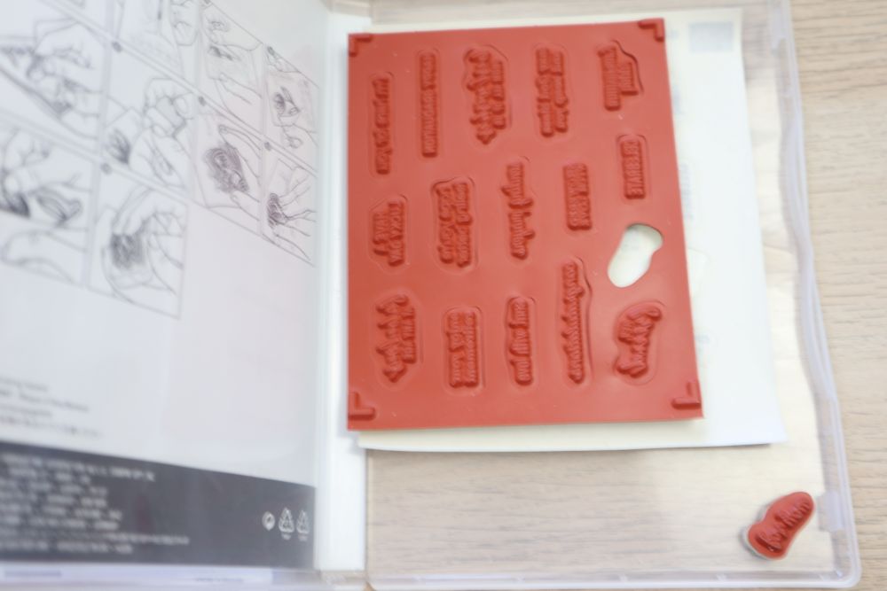 Itty Bitty Greetings stamp set – red rubber stamp sheet showing multiple small sentiment stamps.