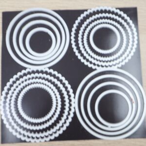 Layering Circles Dies displayed on black magnetic sheet showing nested circle and scalloped circle dies