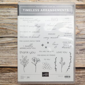 Timeless Arrangements photopolymer stamp set featuring 26 sentiments and floral line art on rustic wood background.